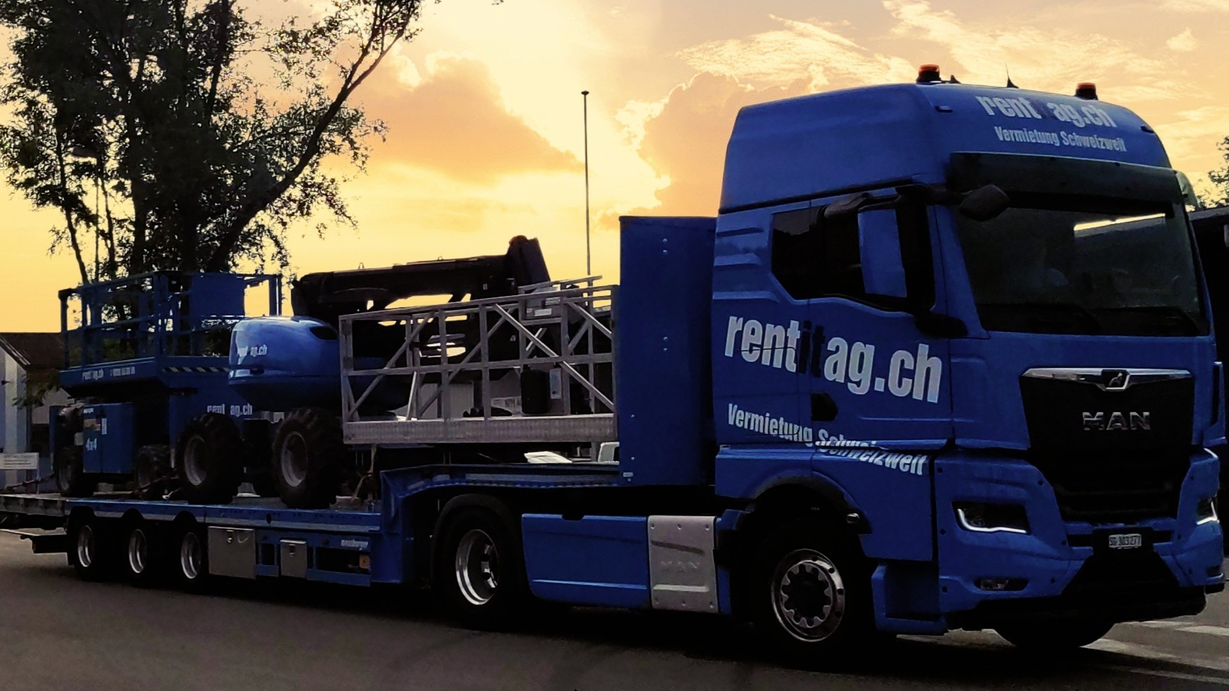 Auflieger transportiert mehrere Hebebühnen im Sonnenuntergang