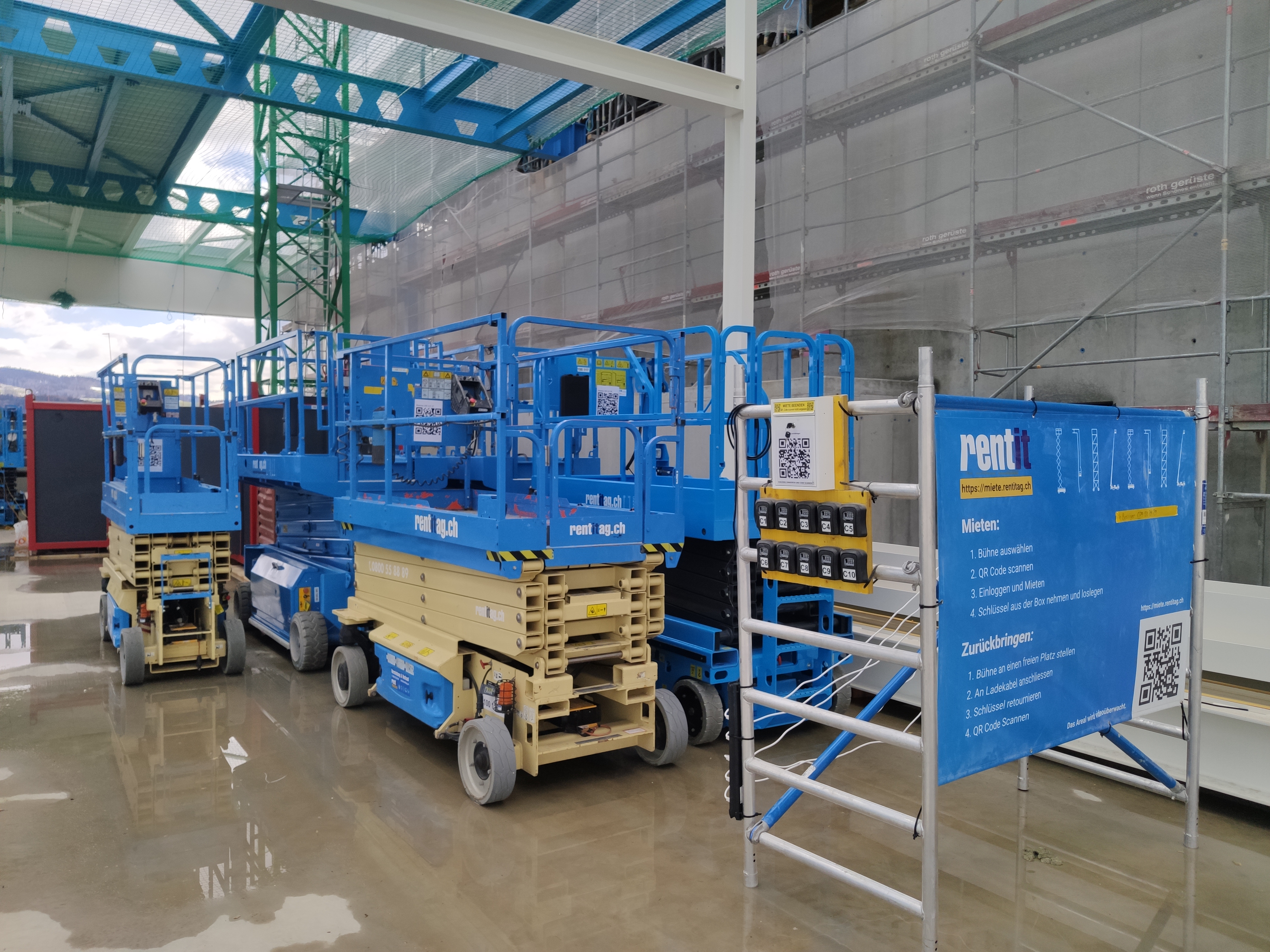 Diverse Scherenbühnen bereit zum mieten. Direkt daneben steht ein Plakat mit der Anleitung zur Verwendung